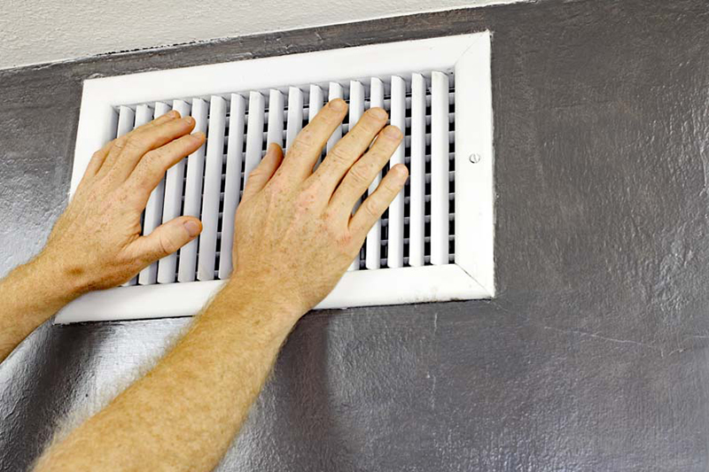 Blog Title: Why Is My AC Blowing Hot Air? Photo: Two Hands in Front of an Air Vent