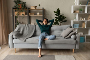 How a Whole-House Humidifier Keeps You Healthy. A woman relaxing on her couch.