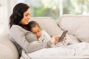 woman and child laying on the couch enjoying their good winter indoor air quality
