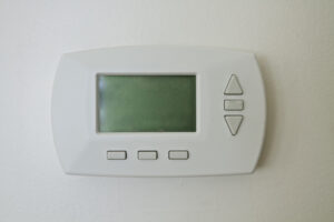 Why Is My Thermostat Blank? Photo of a thermostat mounted on a wall with a blank screen.