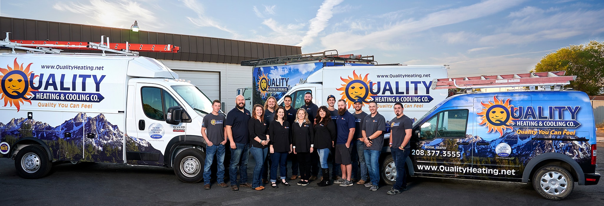 The Quality Heating & Cooling team, standing in front of their three service vans outside.